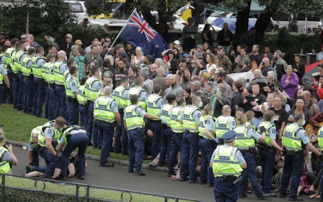 Police officers hold a person on the ground as they make arrests on the third day of protests at Parliament, 10 February 2022. protests.