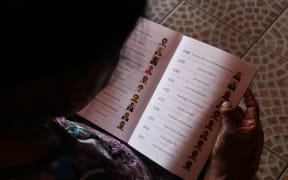 A prospective voter in Fiji studies her voter instruction booklet. November 2018