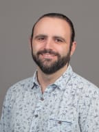 Relaxed smiling William Ray with a grey background