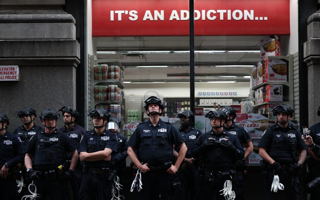 NYPD Strategic Response Group police officers stand outside Federal Plaza Immigration Court during during the 'No Kings' national rally.