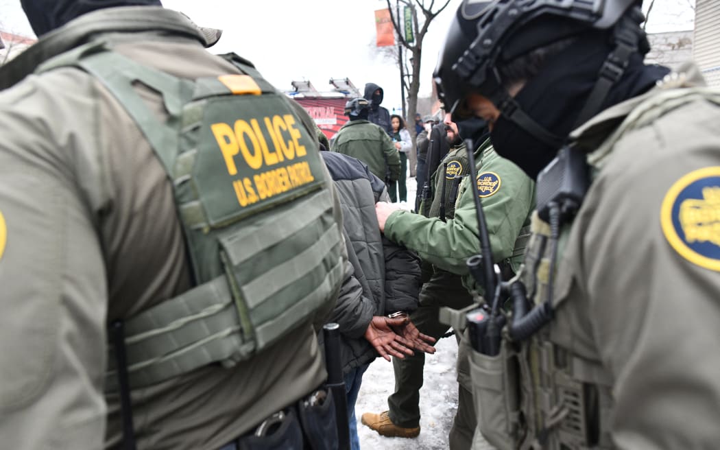 US Border Patrol agents detain a man in Minneapolis, Minnesota, on January 8, 2026. A US Immigration and Customs Enforcement (ICE) agent shot and killed an American woman on the streets of Minneapolis January 7, leading to huge protests and outrage from local leaders who rejected White House claims she was a domestic terrorist. The woman, identified in local media as 37-year-old Renee Nicole Good, was hit at point blank range as she apparently tried to drive away from agents who were crowding around her car, which they said was blocking their way. (Photo by Octavio JONES / AFP)