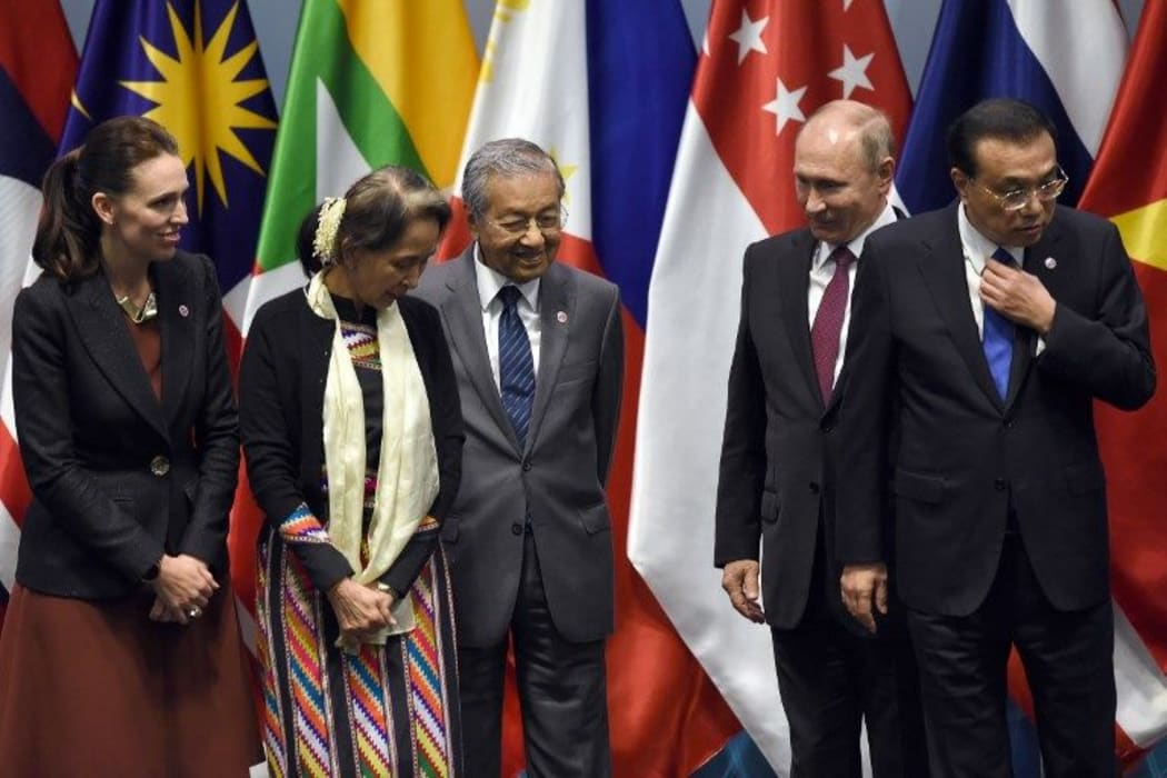 Prime Minister Jacinda Ardern, Myanmar State Counsellor Aung San Suu Kyi, Malaysia's Prime Minister Mahathir Mohamad, Russian President Vladimir Putin and Chinese Premier Li Keqiang arrive on stage to pose for a group photo with other leaders.