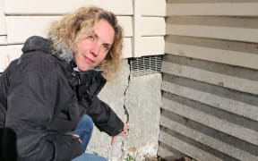 Georgia Scott points out the cracked foundation in the her house.