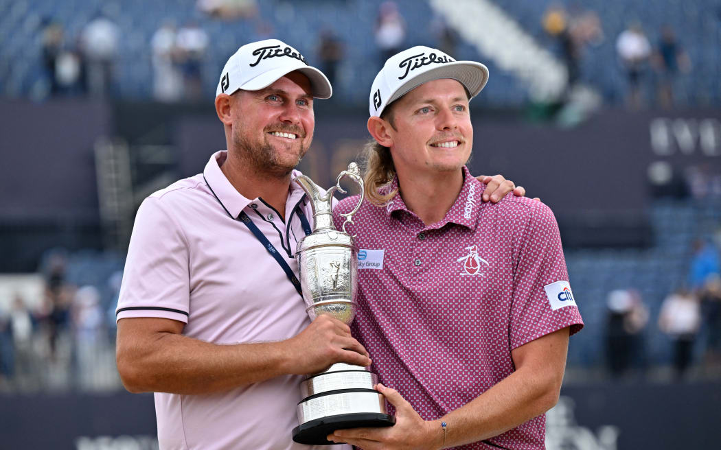 Australia's Cameron Smith and his caddie Sam Pinfold (L) pose with the Claret Jug, the trophy for the Champion golfer of the year after winning the 150th British Open Golf Championship on The Old Course at St Andrews in Scotland on July 17, 2022.