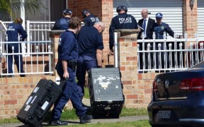 Forensic experts collect evidence from a house in Sydney a part of  Australia's largest ever counter-terrorism raid.