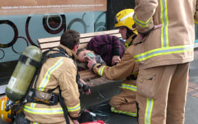 A woman being attended by fire fighters opposite Wellington railway station.