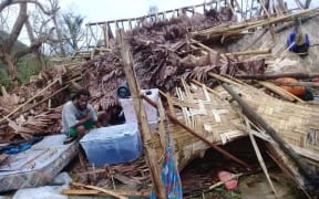 A man searches the wreckage of his house in Ranwas, Pentecost.