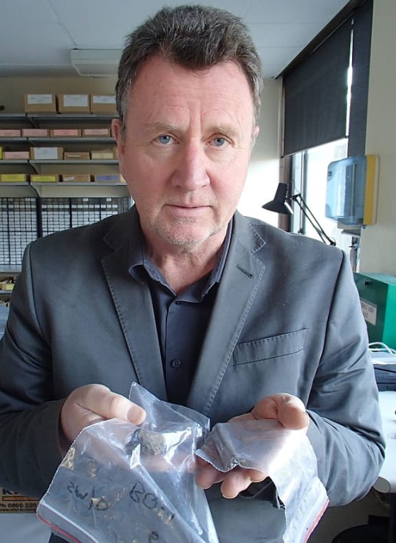 Archaeologist Ian Barber holds kuri bones collected from midden sites in the South Island.