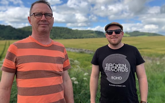 John Rae and Ben Wilcock standing in a field, looking at the camera.