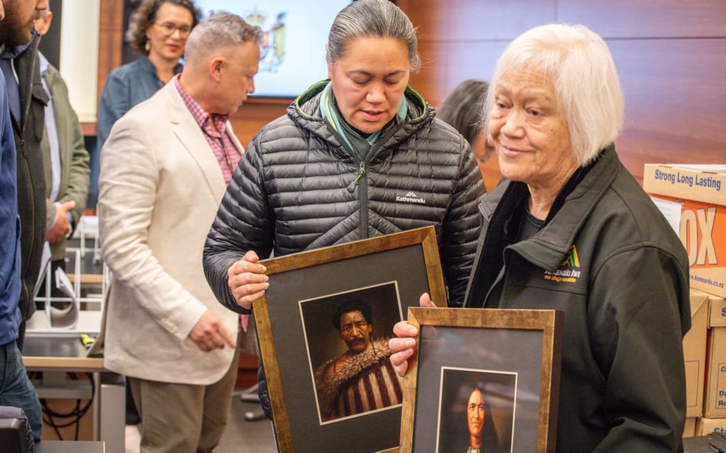 Whānau carry pictures of their ancestors into the High Court.