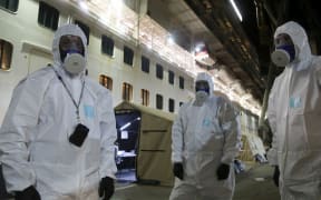 This handout photo taken and released on April 9, 2020 by the New South Wales Police Force shows police officers about to raid the coronavirus-stricken Ruby Princess cruise ship and seize its black box at Port Kembla, Australia.