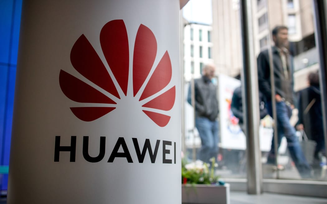 (FILES) In this file photo taken on April 29, 2019 A pedestrian walks past a Huawei product stand at an EE telecommunications shop in central London.