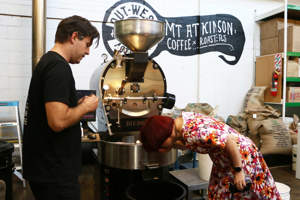 Jacob Parsons, director of Mt Atkinson Coffee Roasters, and electorate MP for New Lynn Deborah Russell examining coffee beans from Uganda.