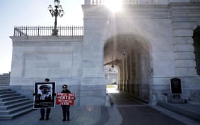 Demonstrators stand outside the U.S. Capitol as the impeachment trial of President Donald Trump begins in the U.S. Senate January 16, 2020 in Washington, DC.