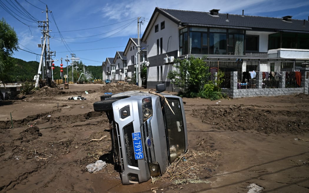 A flood damaged car is seen following heavy rains in Huairou district, on the outskirts of Beijing.