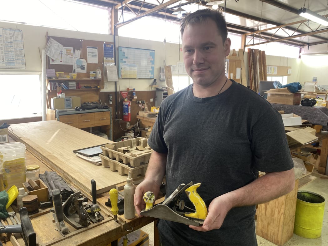 Julian Shaw holds one of Neil Stocker’s tools. Many are still in use in the Washdyke workshop.