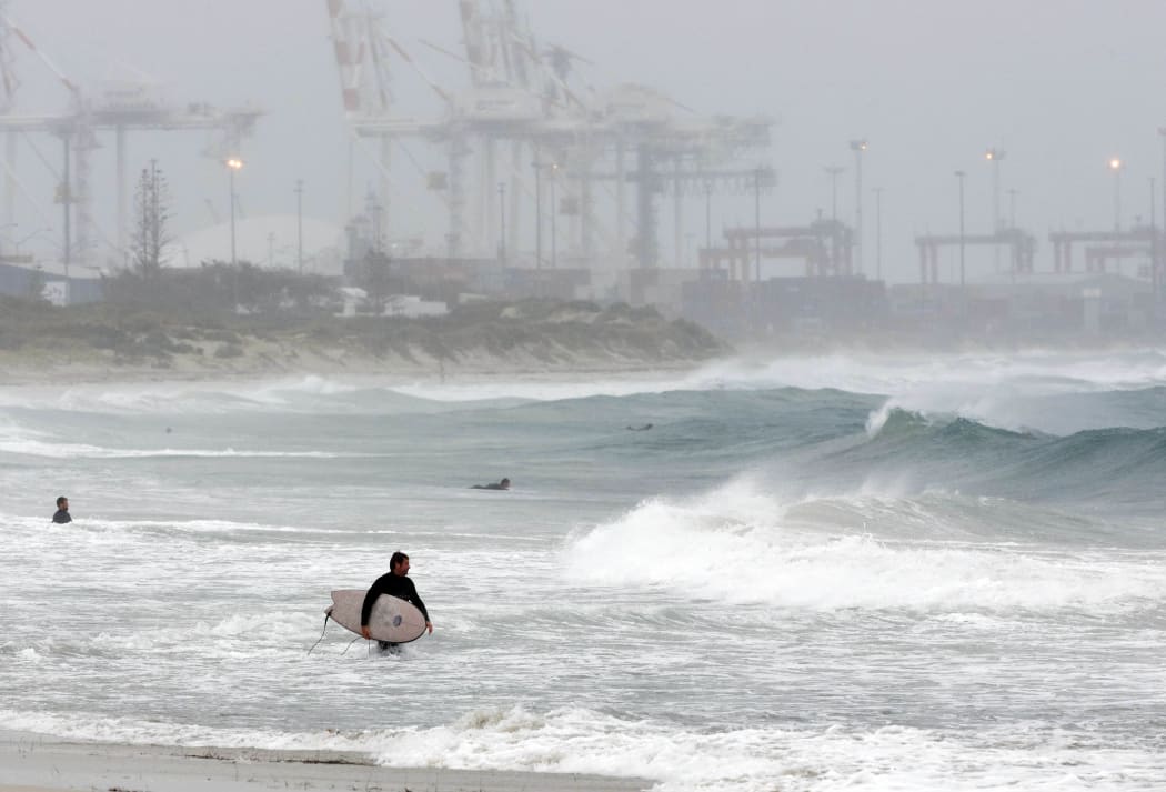Surfers take to the water at Cottesloe beach in Perth, to take advantage of unusually large waves