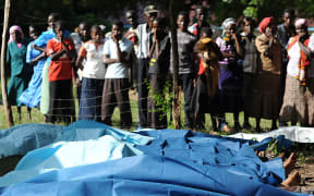 Family members wait to collect bodies of their relatives at Mpeketoni hospital in Lamu county, after at least 48 heavily-armed gunmen attacked the town.