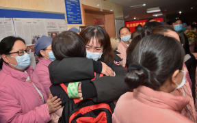 A member of a 121-member medical team headed from Beijing to Wuhan is hugged by a colleague at Beijing Hospital.