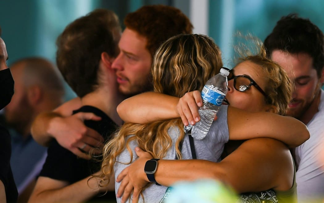 People hug as they wait for news about relatives at the Community Center in Surfside north of Miami Beach, Florida on June 25, 2021.