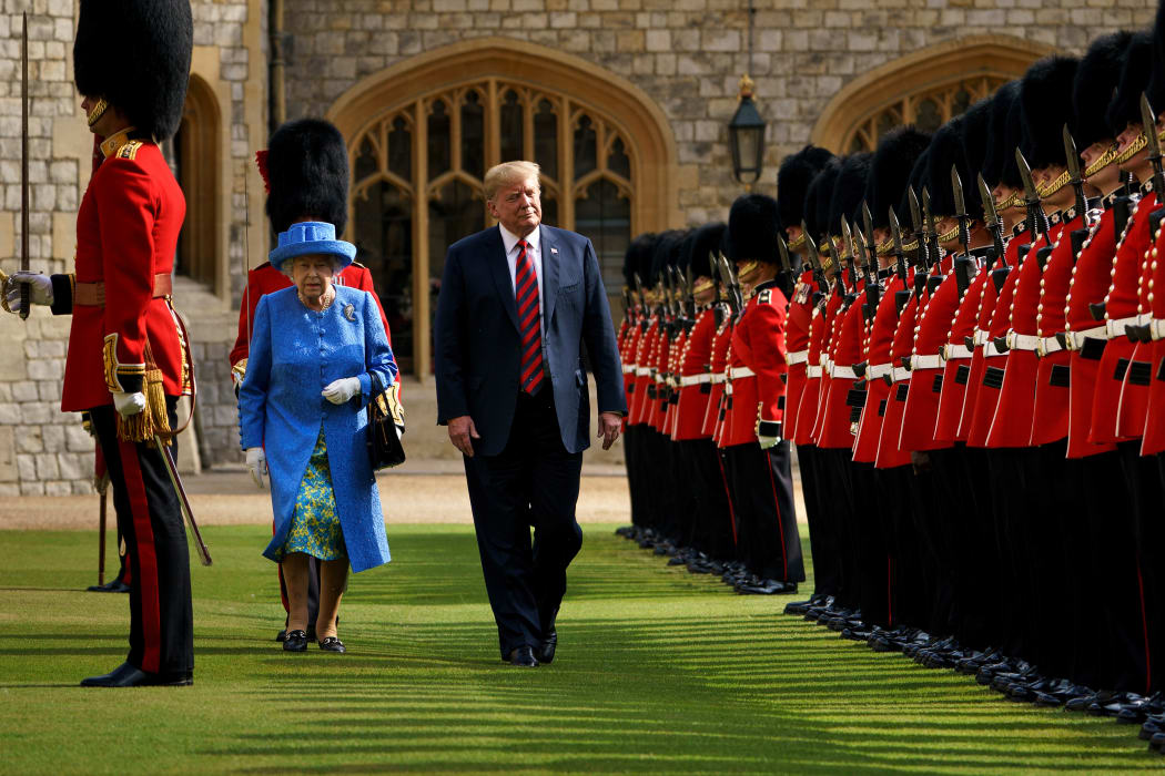 US President Donald Trump is accompanied by Britain's Queen Elizabeth II as he inspects the Guard of Honour at Windsor Castle in Windsor, west of London, on the second day of Trump's UK visit.