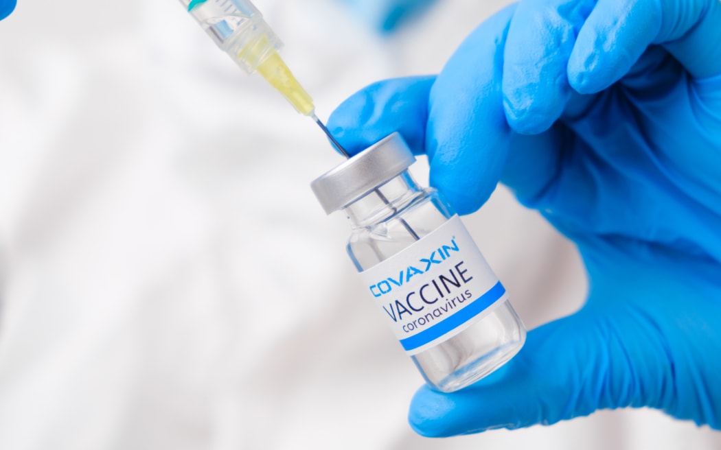 Covaxin vaccine against coronavirus collected into the syringe by health worker or doctor in protective gloves and PPE suit, April 2021, San Francisco, USA.