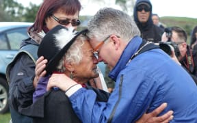 New Plymouth mayor Andrew Judd is embraced by Parihaka elder Te Whero o te Rangi Bailey after the peace hiko entered Parihaka.