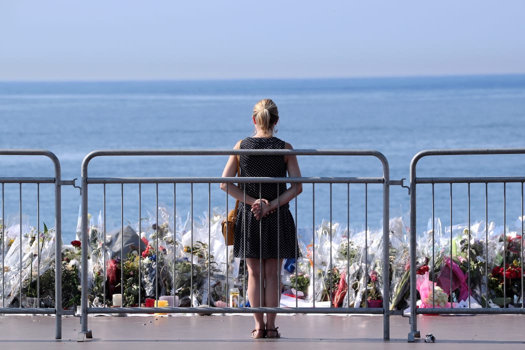 A woman stands by a make-shift memorial for the victims of the Nice truck attack.
