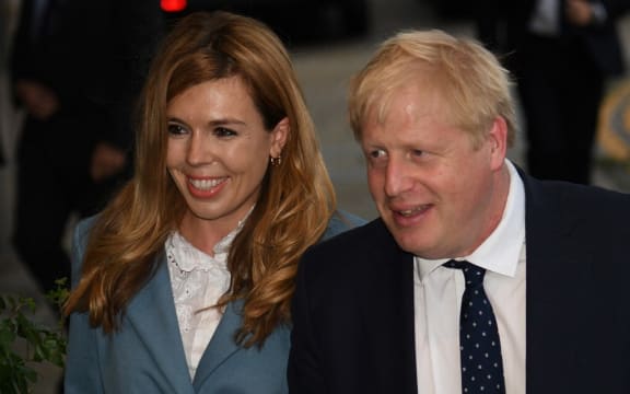 Britain's Prime Minister Boris Johnson walks with his partner Carrie Symonds as they arrive at The Midland, near the Manchester Central convention complex in Manchester, northwest England on September 28, 2019,