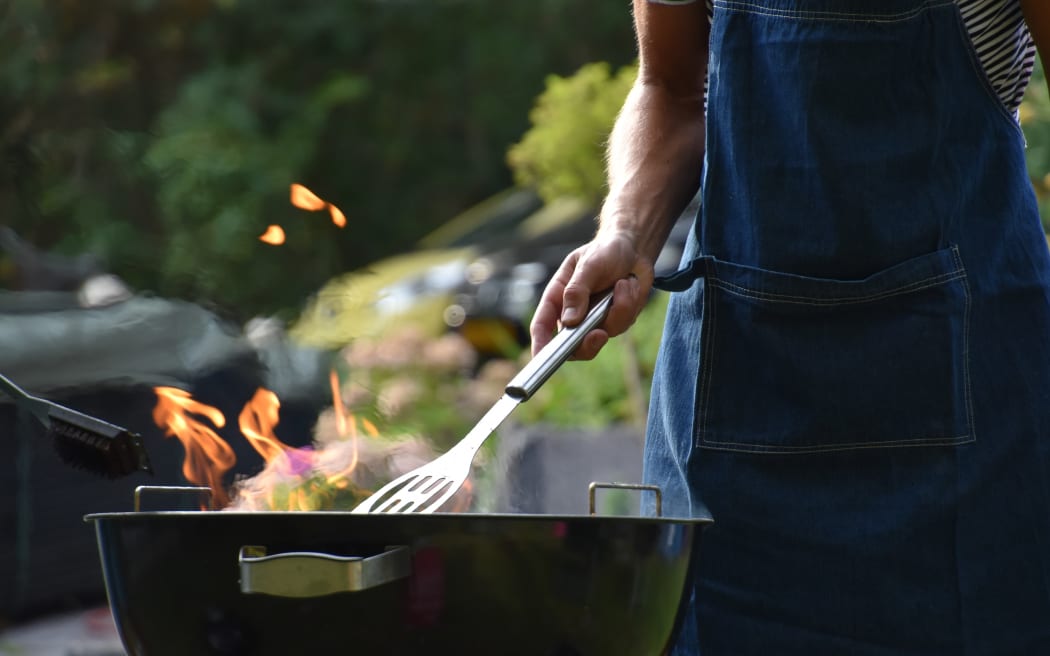 Person standing at a barbecue