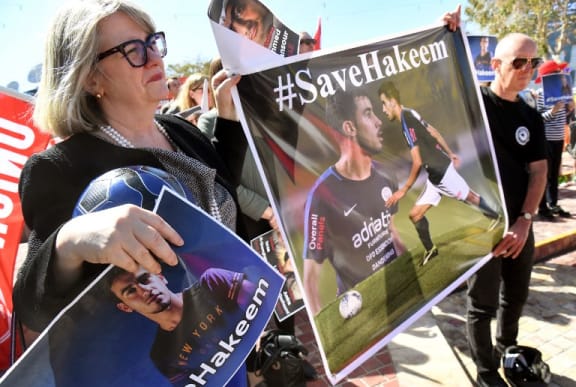 People hold up banners at a rally in Melbourne on February 2, 2019, supporting Bahraini refugee footballer Hakeem al-Araibi who was detained by Thai immigration authorities in late November after arriving in Bangkok from Australia for a vacation with his wife. -