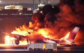 This photo provided by Jiji Press shows a Japan Airlines plane on fire on a runway of Tokyo's Haneda Airport on January 2, 2024. A Japan Airlines plane was in flames on the runway of Tokyo's Haneda Airport on January 2 after apparently colliding with a coast guard aircraft, media reports said.