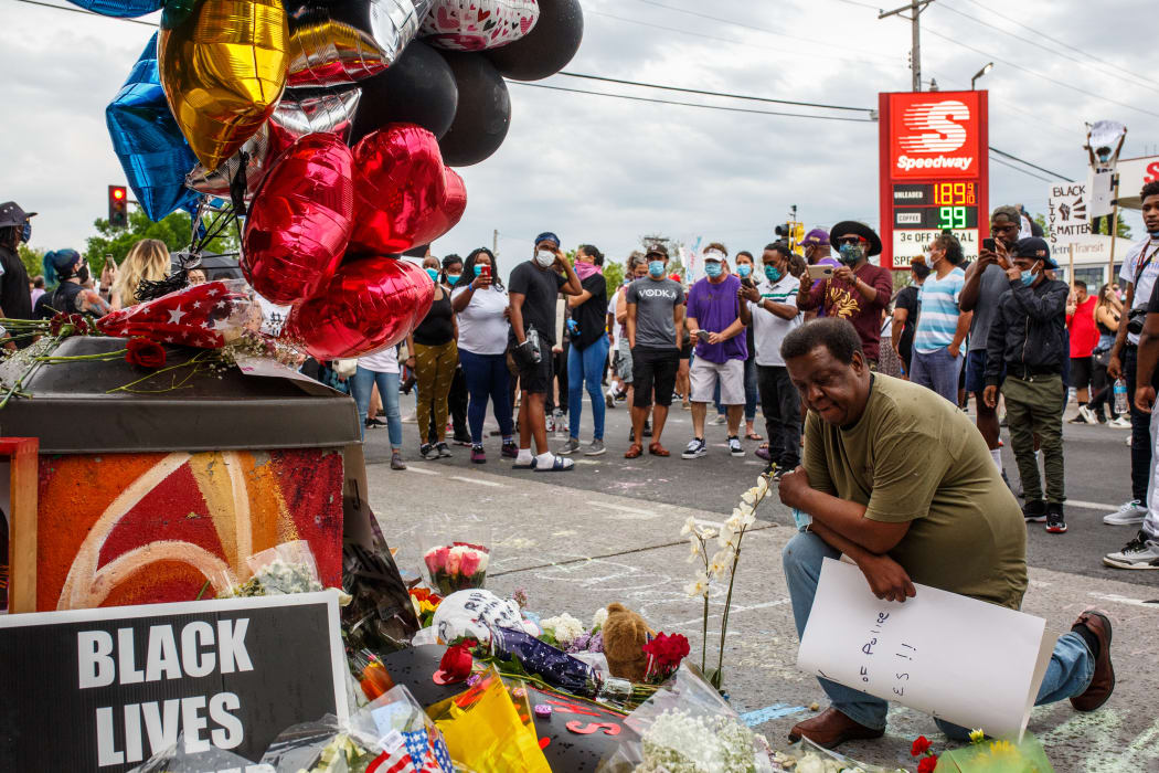 A man prays in front of a makeshift memorial in honor of George Floyd who died in custody on May 26, 2020 in Minneapolis, Minnesota.