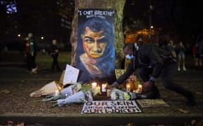 SYDNEY, AUSTRALIA - JUNE 6: A man places a candle at a vigil with a portrait of David Dungay during a protest against Aboriginal deaths in custody in Sydney, Australia on June 6, 2020.