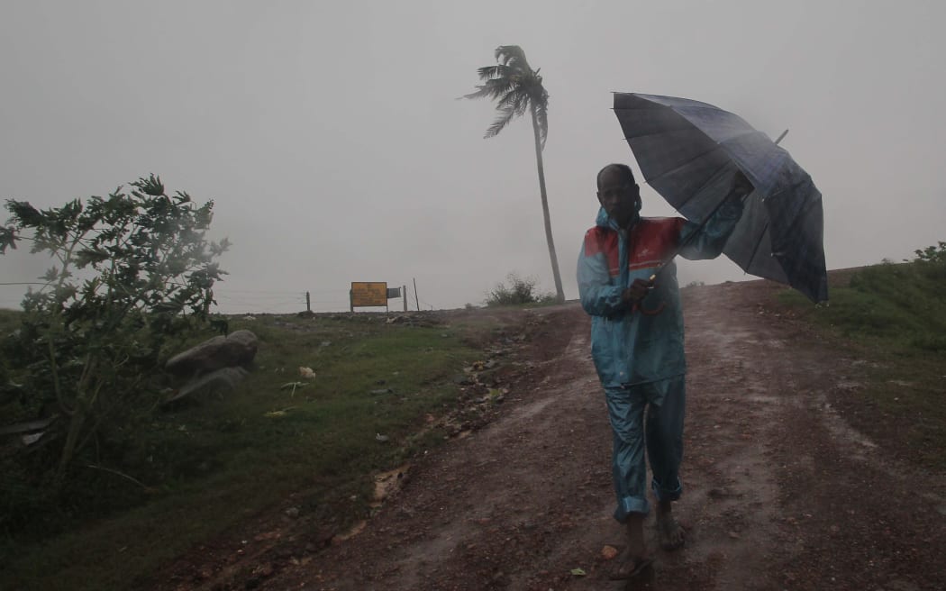 Villagers are seen as government official remove uprooted trees after cyclone Bulbul crossing in the Bay of Bengal Sea's eastern coast, on November 9, 2019 near eastern Indian state odisha just above 120 km away from its capital city Bhubaneswar.