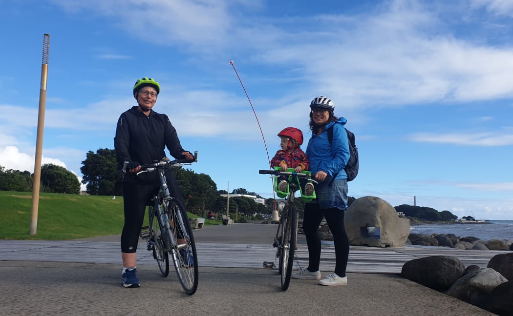 Cyclists Sue and Hannah, with Edie in New Plymouth are happy to see Len Lye's Wind Wand back in its usual spot.