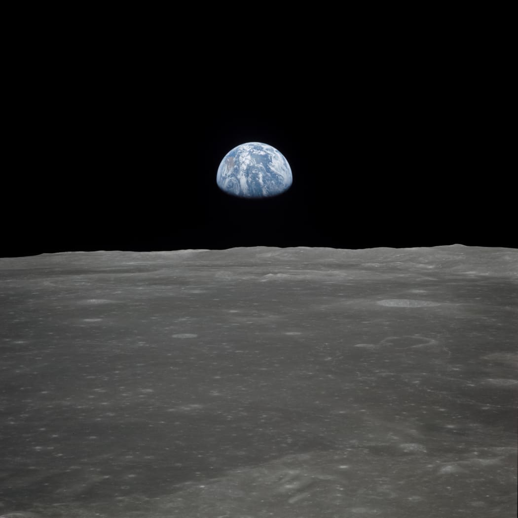 This July 1969 NASA file photo obtained July 16, 2019 shows a file view of Earth rising over the Moon's horizon taken from the Apollo 11 spacecraft. - The lunar terrain pictured is in the area of Smyth's Sea on the nearside.