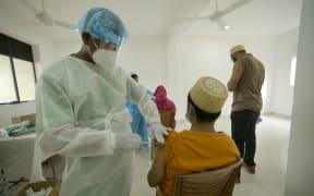 A Sri Lankan health worker  wearing  protective gear administers a jab of  Chinese-made Sinopharm vaccine  against Covid-19 virus  in Colombo, Sri Lanka on 14 May 2021..