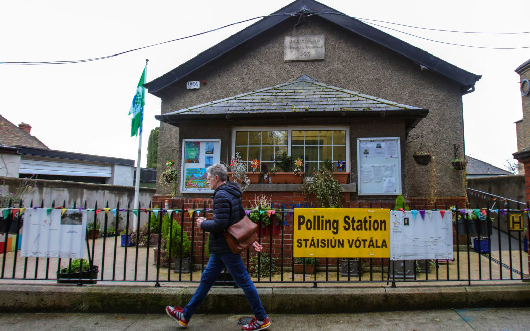 A pedestrian passes a Polling station in the Drumcondra area of Dublin, Ireland on March 5, 2024, ahead of the Irish Referendum on Friday. Ireland prepares to vote Friday on constitutional references to the family and women's role in the home after campaigns that have honed in on vague wording, 'mansplaining' and panic over polygamy. (Photo by PAUL FAITH / AFP)