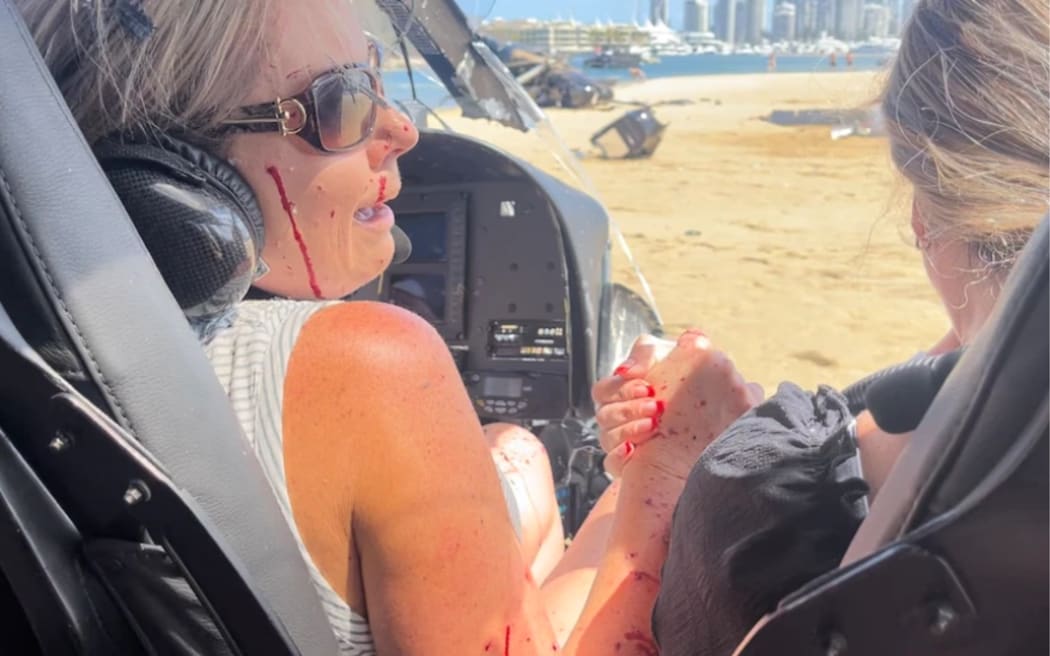 Marle Swart and Elmarie Steenberg hold each other in shock moments after their helicopter crash lands on a sand bar in Australia's Gold Coast.