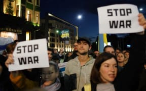 People hold anti-war banners during a protest in Belgrade on September 21, 2022, after Russia President dramatically escalated his seven-month war in Ukraine by calling up 300,000 military reservists. (Photo by OLIVER BUNIC / AFP)