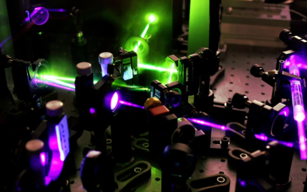 A set of lenses and purple and green lasers