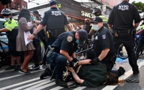 Police officers cuff a protestor during a "Black Lives Matter" protest near Barclays Center on May 29, 2020 in the Brooklyn borough of New York City, in outrage after George Floyd, an unarmed black man, died while being arrested