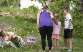 Families pay their respects on June 8, 2021, at a makeshift memorial near the site where a man driving a pickup truck struck and killed four members of a Muslim family in London, Ontario, Canada. Canadian Prime Minister Justin Trudeau on Tuesday labeled as a "terrorist attack" the killing of four members of a Muslim family, who were run down by a man driving a pick-up truck. "This killing was no accident. This was a terrorist attack, motivated by hatred, in the heart of one of our communities," Trudeau said during a speech at the House of Commons. The suspect, identified as Nathaniel Veltman, 20, was arrested shortly after the June 6 attack, has been charged with four counts of first-degree murder and one count of attempted murder. (Photo by Nicole OSBORNE / AFP)