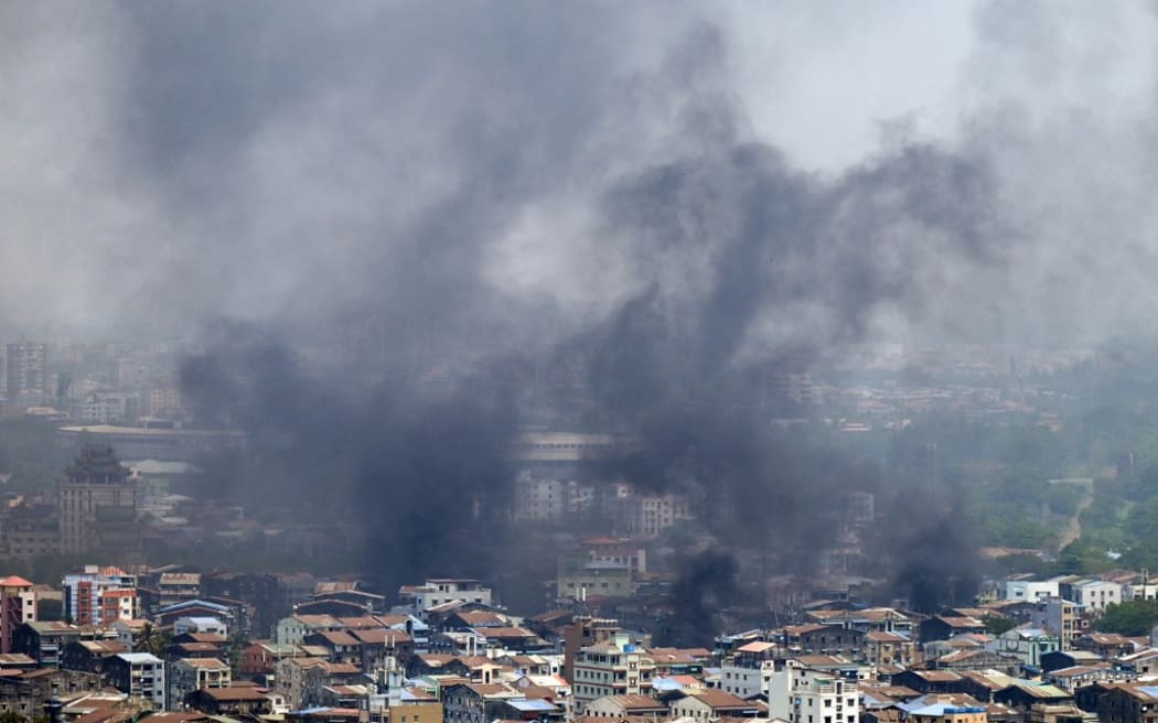 Smoke rises over Tamwe township in Yangon on March 27, 2021, as security forces continue their crackdown on protests against the military coup. (Photo by STR / AFP)