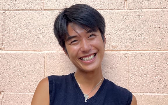 Albert Cho smiling with a brick wall behind him