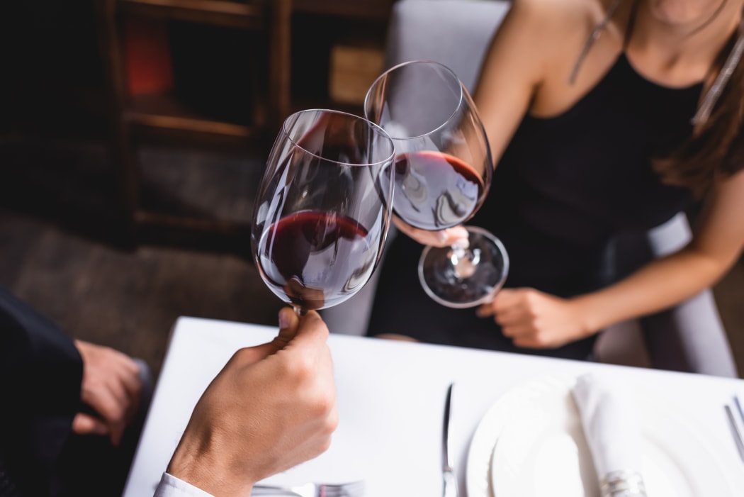 Couple clinking wine glasses.