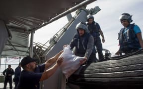 NZ fisheries officer hands down confiscated fish to crew on board HMNZS Hawea during fisheries and customs patrols in Fiji in August 2018.