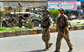 Afghan soldiers patrol outside a prison during an ongoing raid in Jalalabad on 3 August 2020.