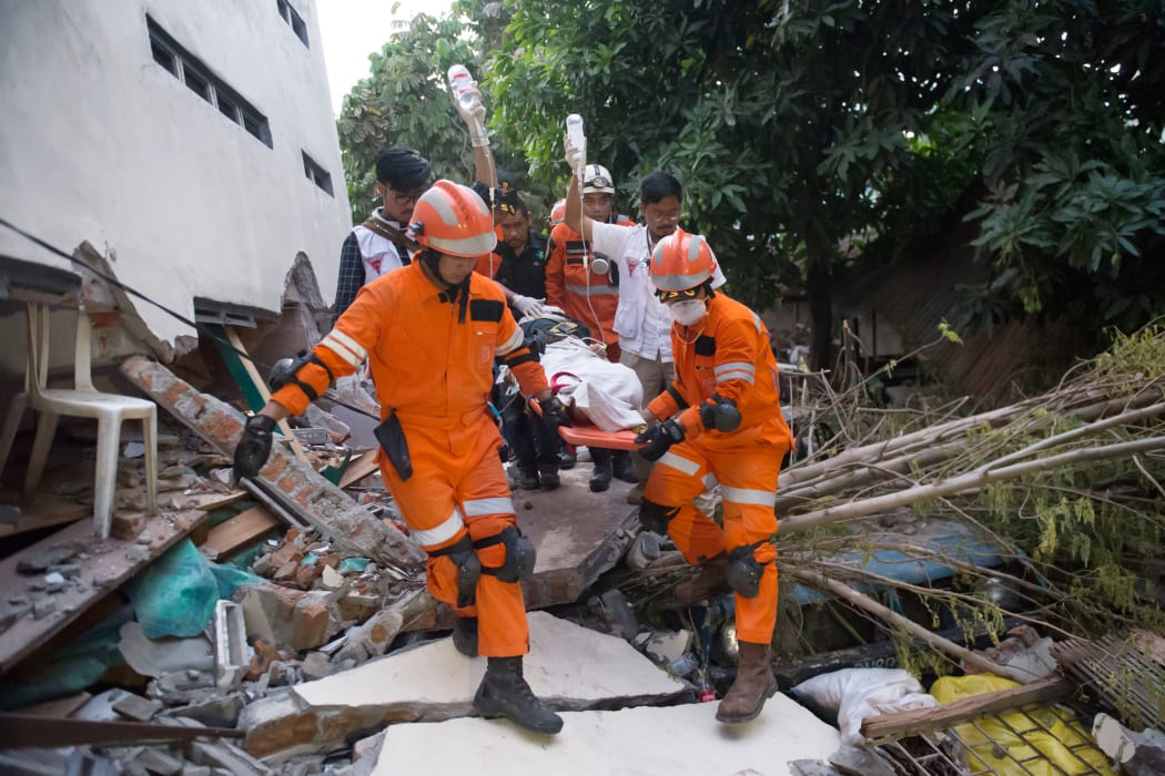 Rescue personnel evacuate earthquake survivor Ida, a food vendor, from the rubble of a collapsed restaurant in Palu, Indonesia's Central Sulawesi.